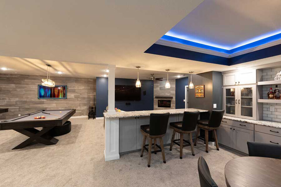 Custom basement wet bar with seating and blue LED accent lighting