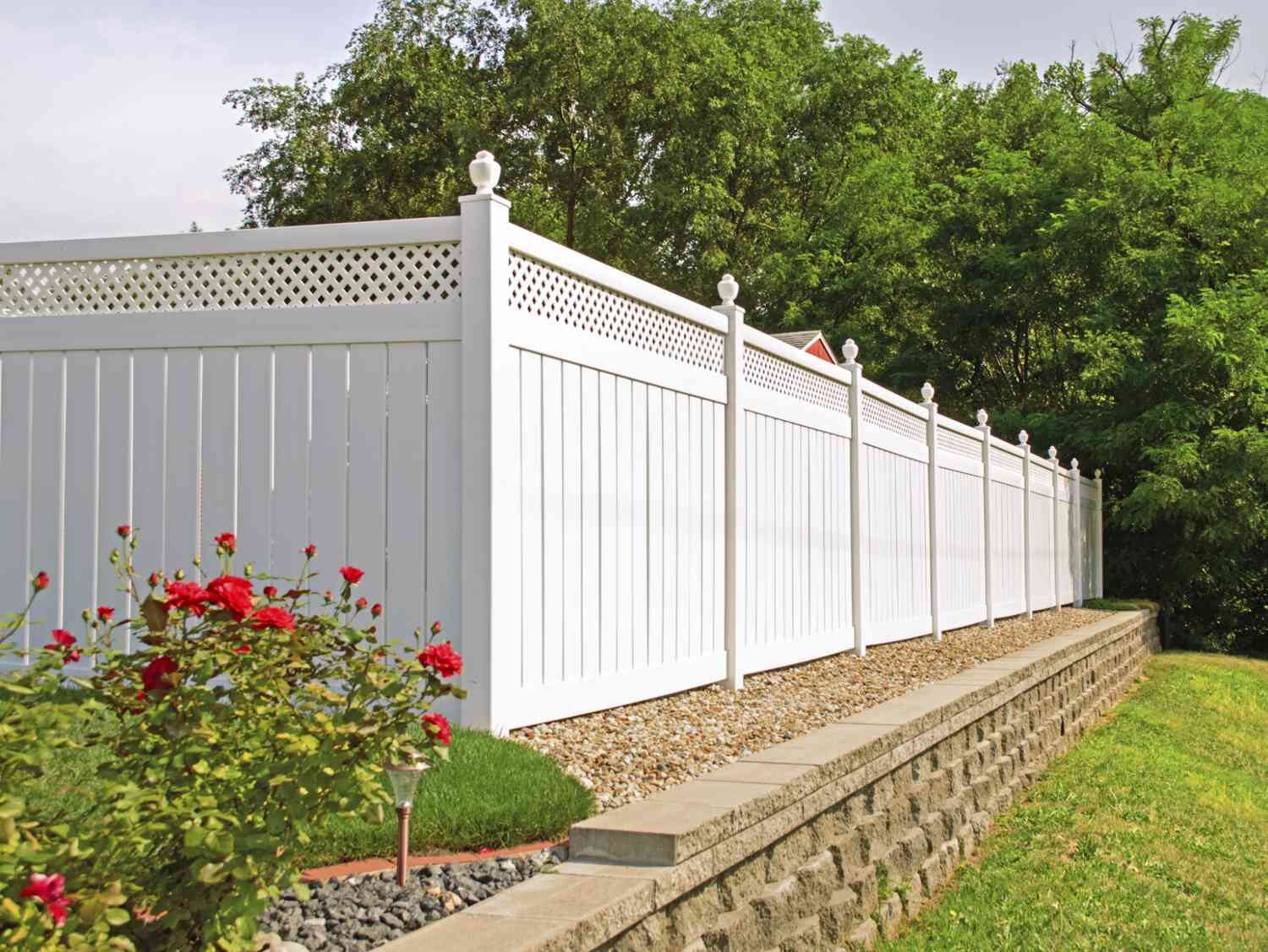 New white vinyl privacy fence along a landscaped yard