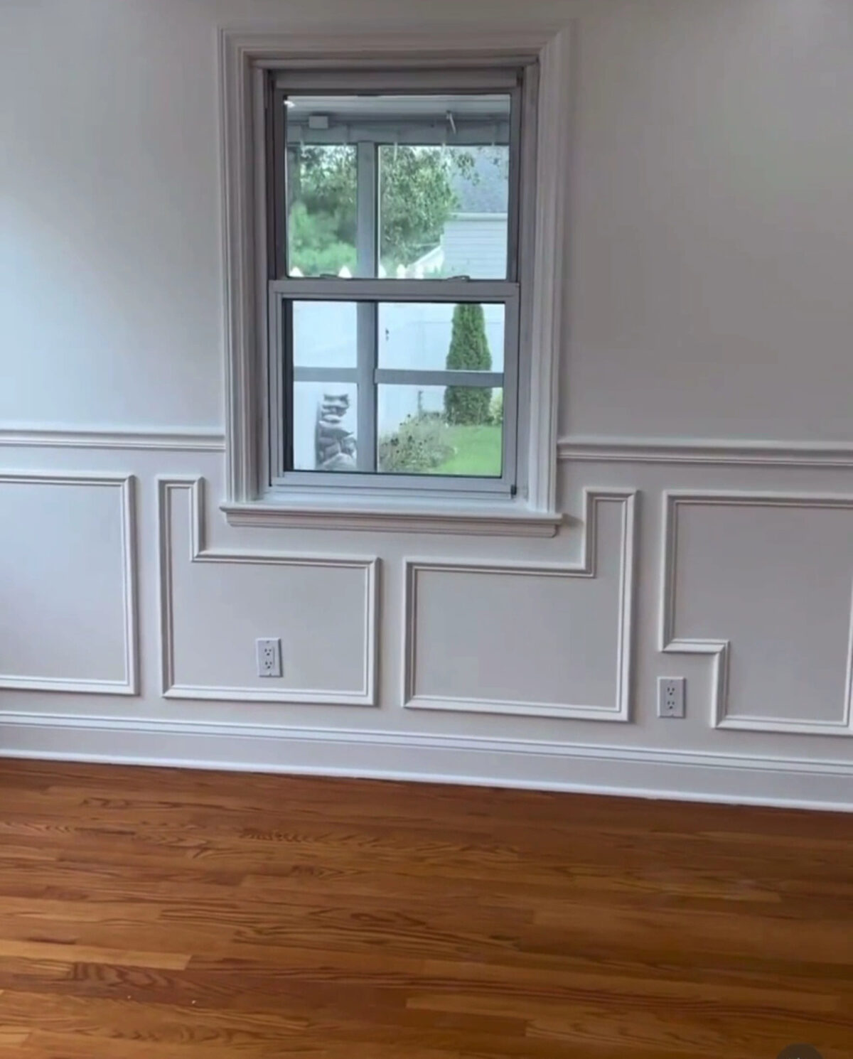 Room with custom wainscoting panels, new window casing and hardwood floors